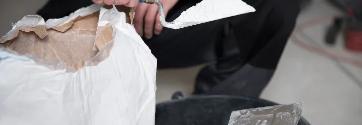 Person trägt Putz mit Kelle auf